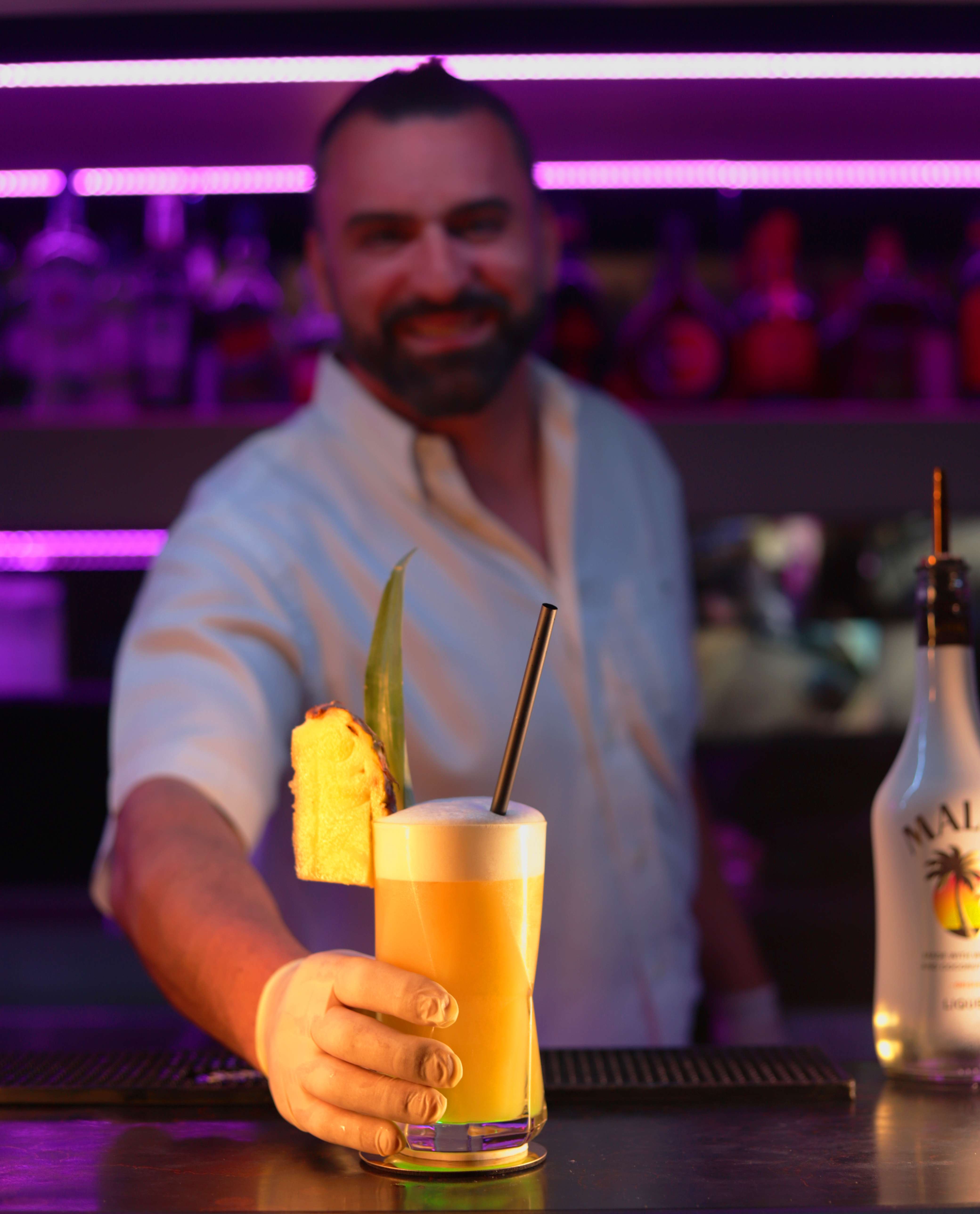 Notre barman préparant un cocktail tropical